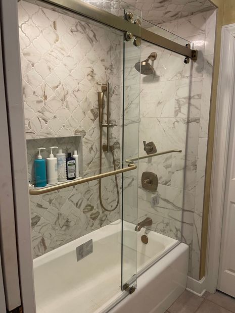 A bathroom with a bathtub and a shower with a glass door.