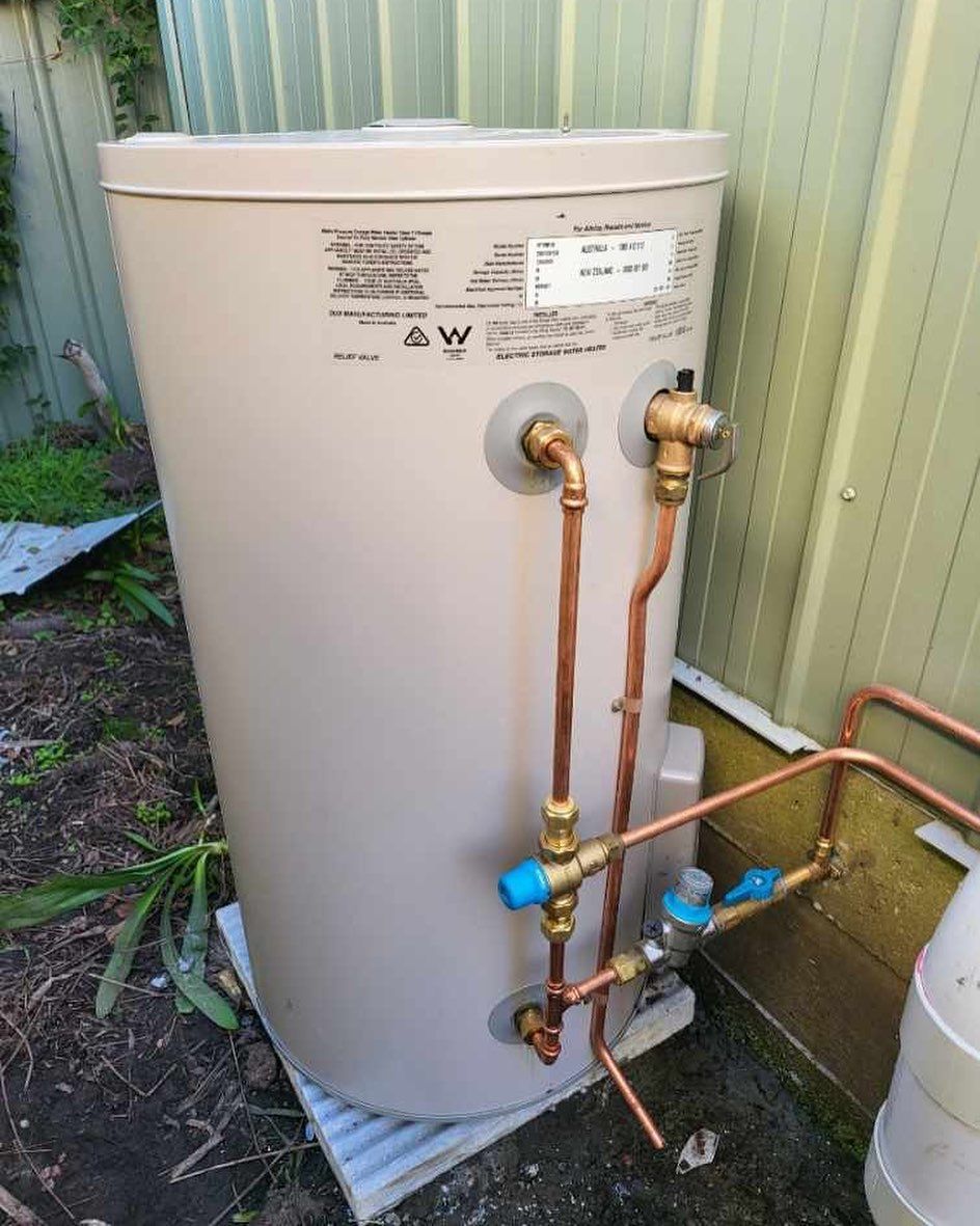 A White Water Heater With Copper Pipes Attached to It — JMJ Plumbing and Electrical NSW In Tumbi Umbi, NSW