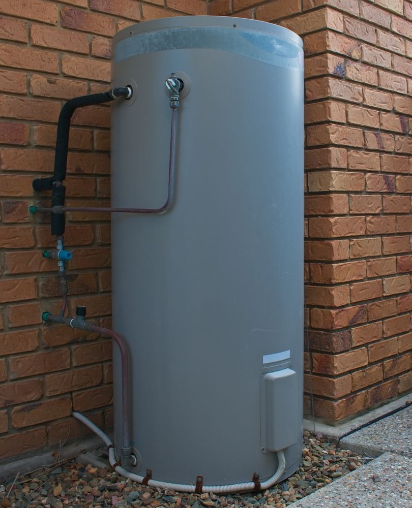 A Gray Water Heater is Attached to a Brick Wall — JMJ Plumbing and Electrical NSW In Tumbi Umbi, NSW