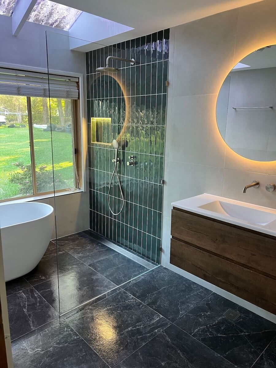 A Bathroom With a Tub , Sink , Mirror and Shower — JMJ Plumbing and Electrical NSW In Tumbi Umbi, NSW