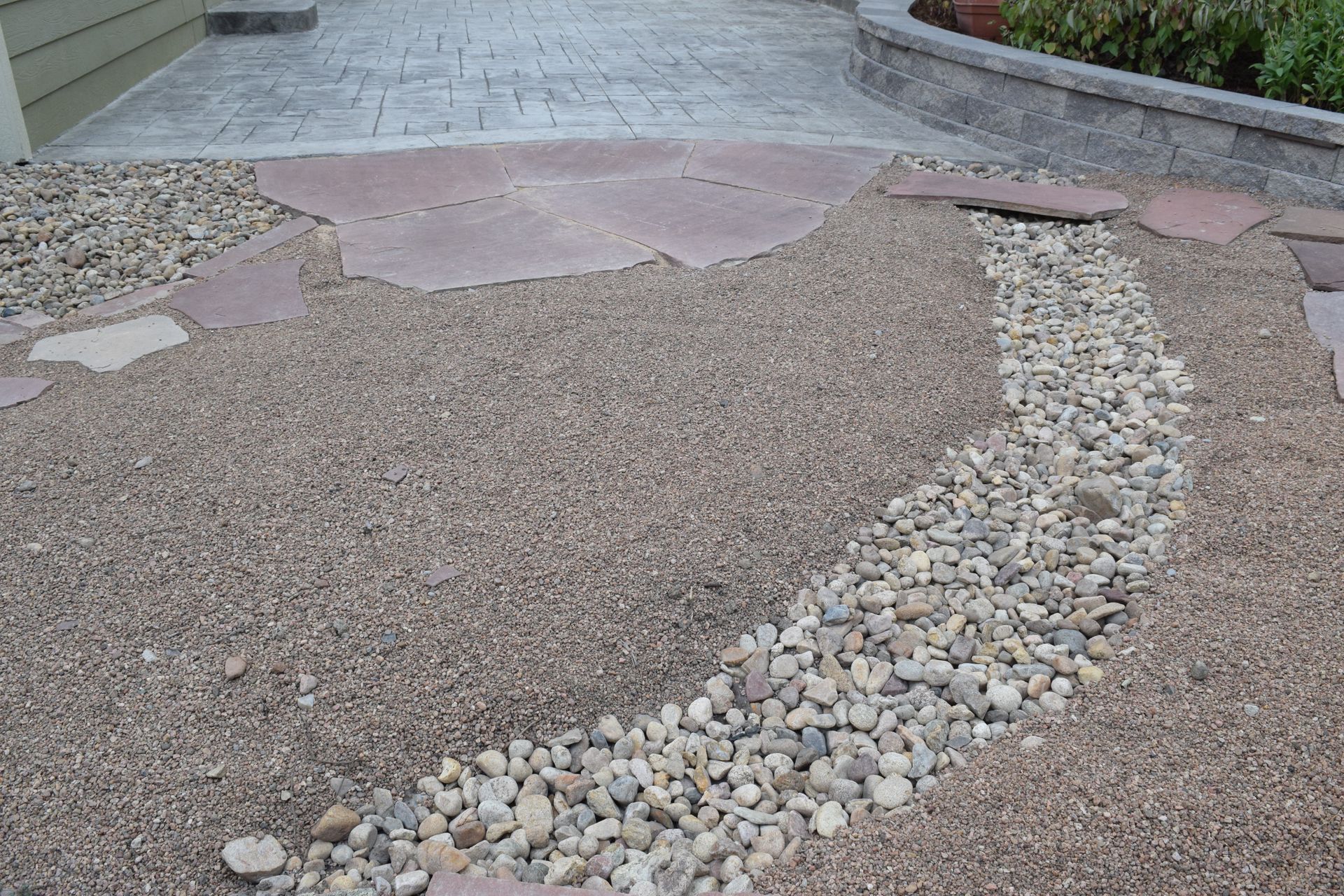 Gravel and stone pathway with stepping stones and a dry creek bed.