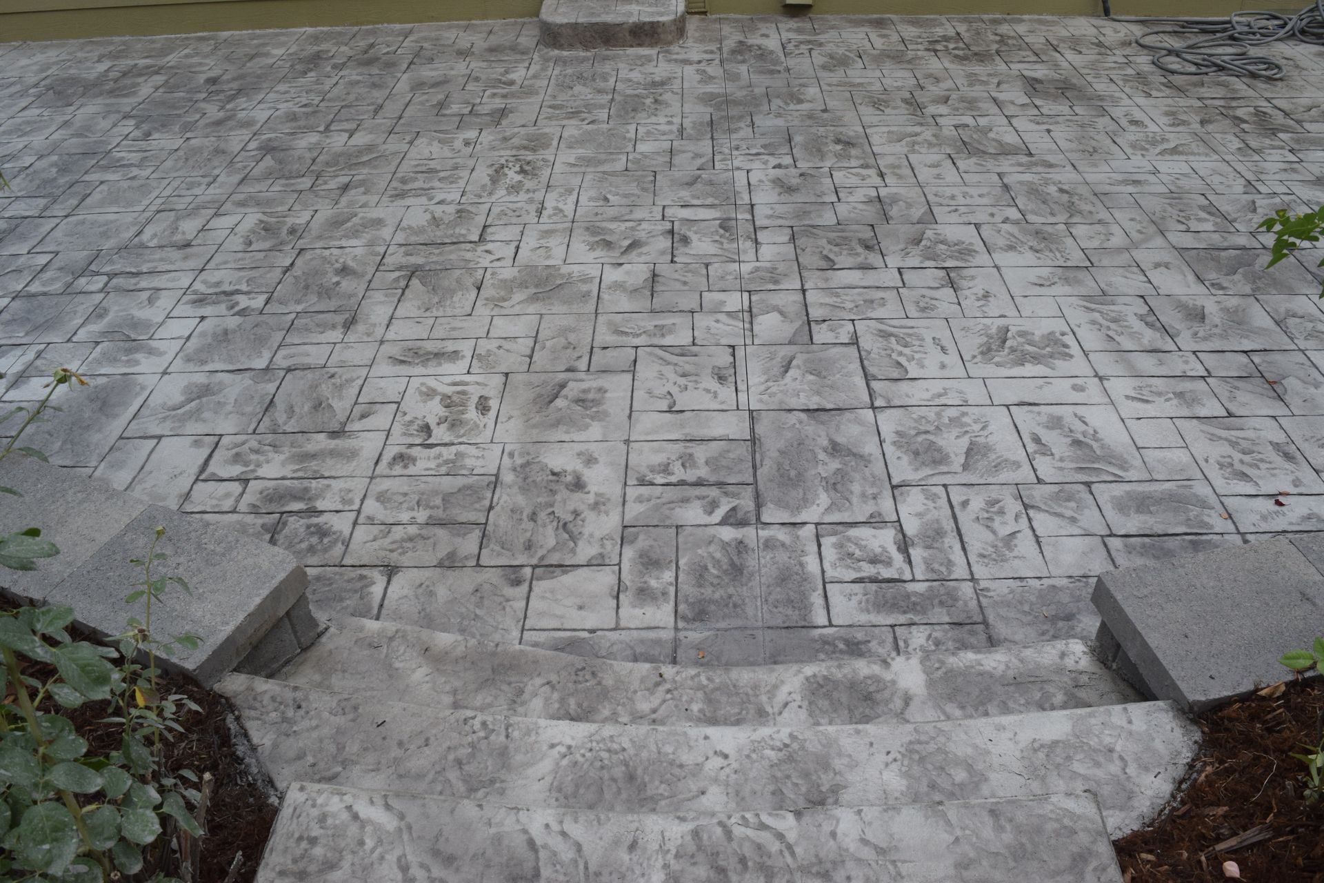Gray stone patio with steps leading down.