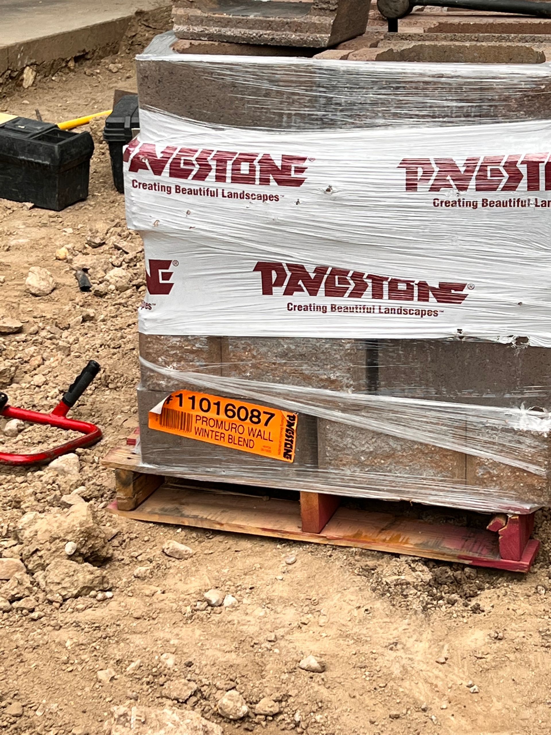 A pallet of bricks wrapped in plastic, with a 