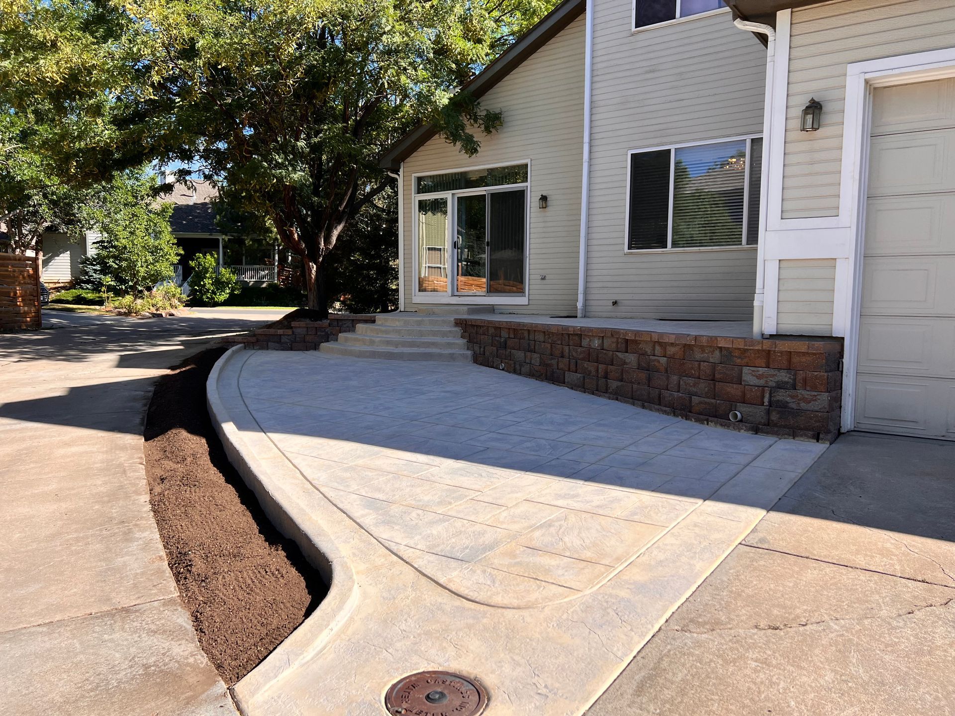 House exterior with concrete driveway and retaining wall.