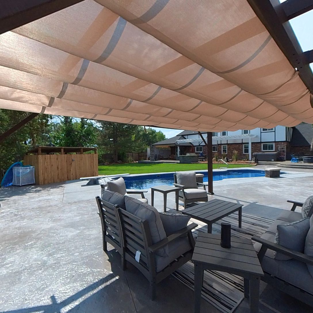 Patio with outdoor furniture, pool, and retractable sun shade.
