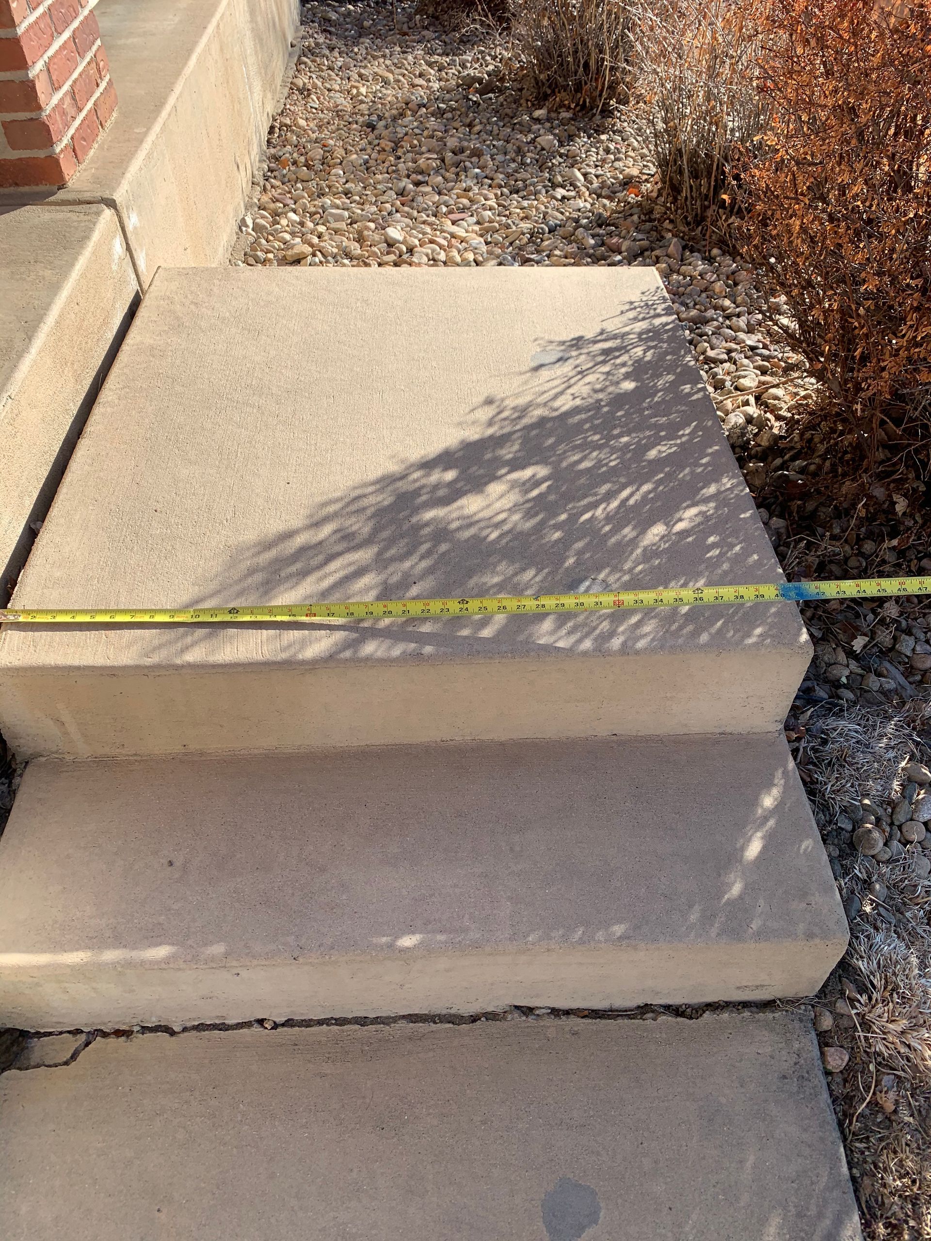 Concrete steps with a measuring tape extended across them.