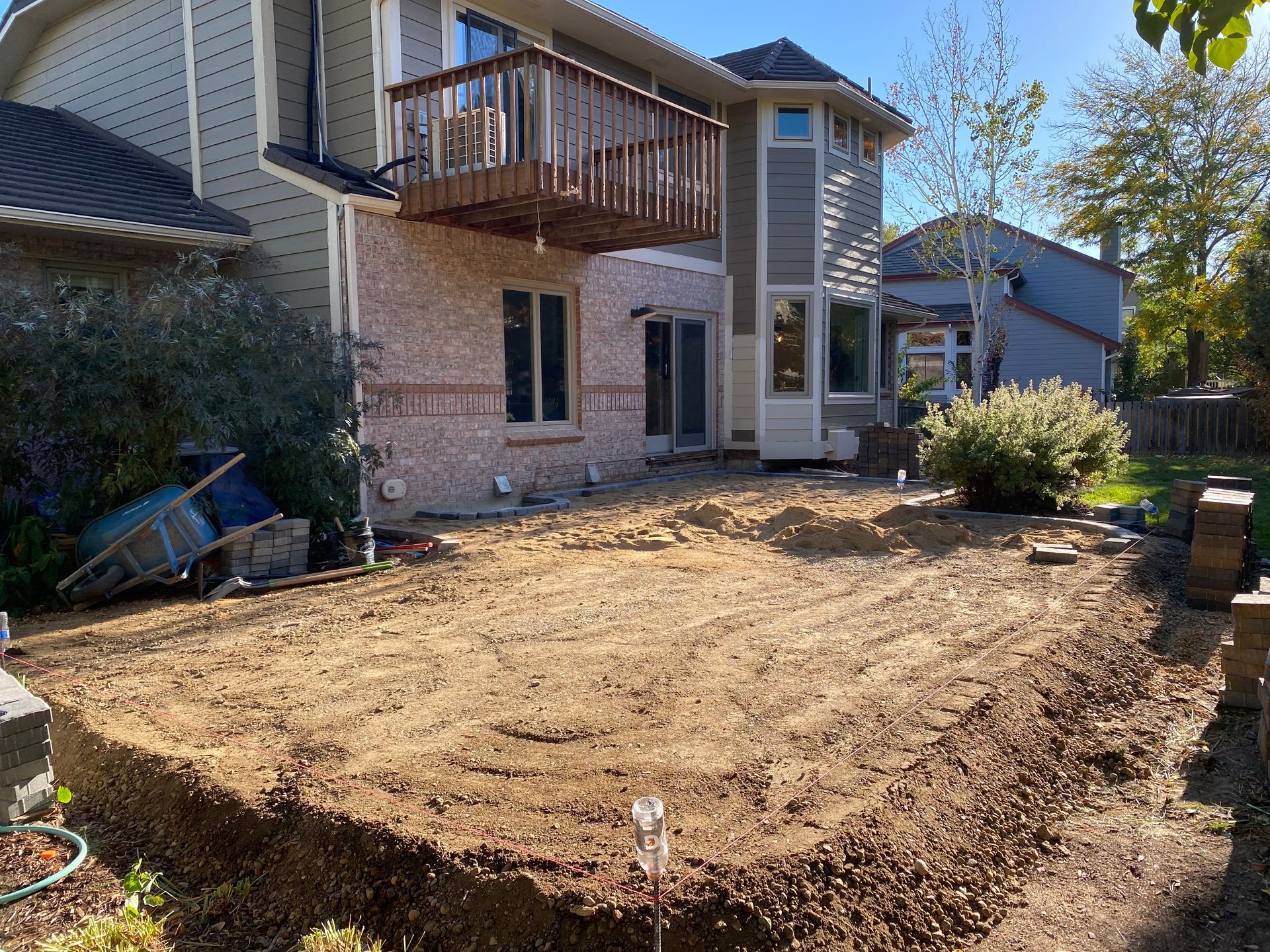 Backyard dirt area ready for landscaping, with house and deck.