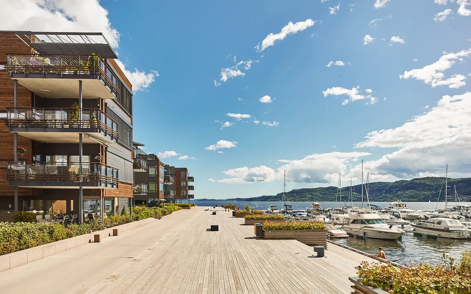 Moderne leilighetsbygg langs bryggepromenaden i Nordre Jarlsberg Brygge med store balkonger og utsikt mot fjorden