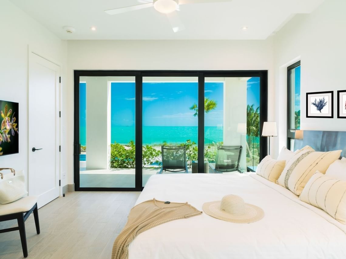 Bright bedroom with large ocean-view sliding doors and minimalist white decor