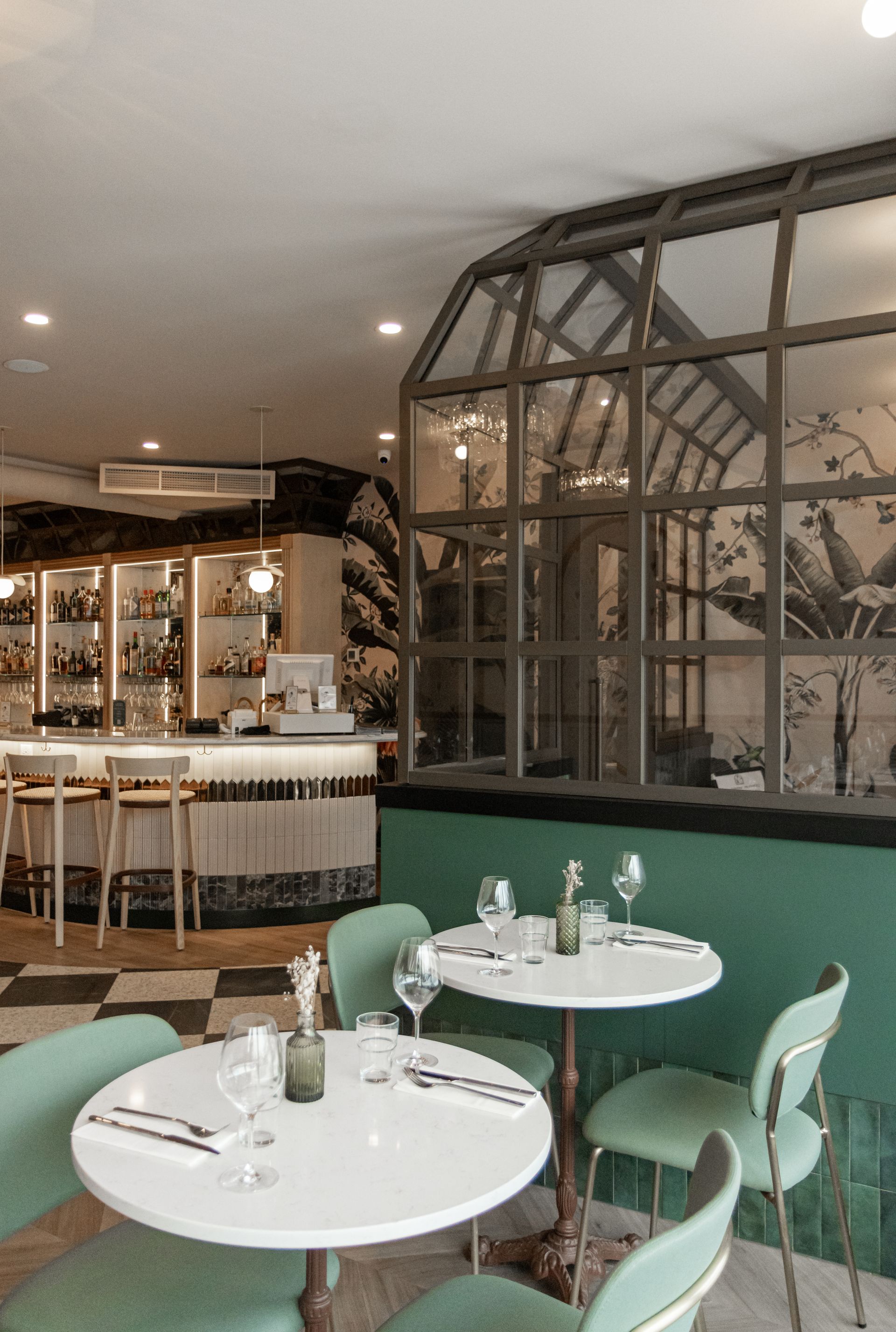Intérieur de café moderne avec chaises vert menthe, tables blanches et cloison vitrée