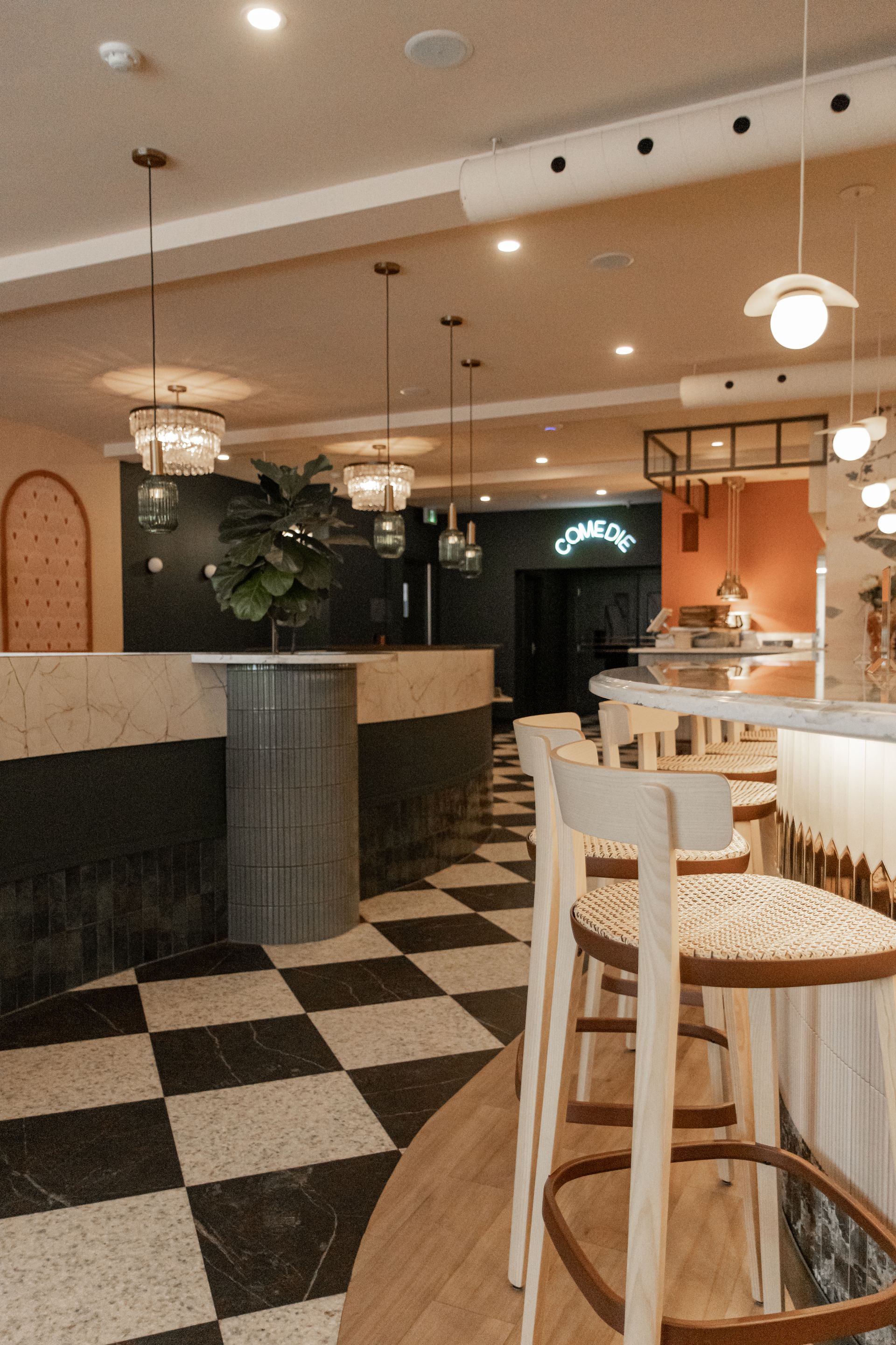 Intérieur de restaurant élégant avec sol à damier, éclairage chaleureux et tabouret de bar blanc près d'une table ronde