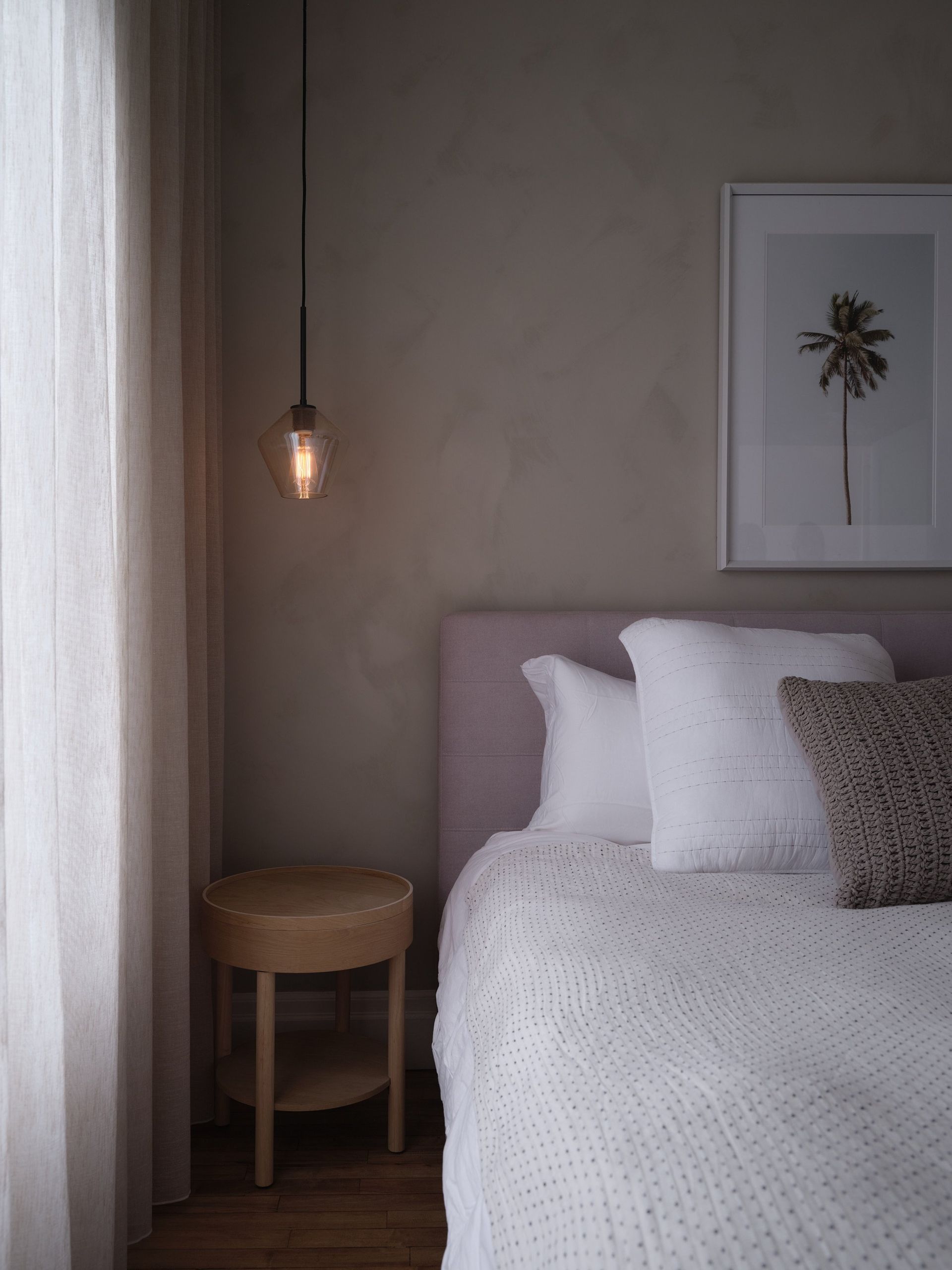 Il y a une photo d'un palmier sur le mur au-dessus du lit.