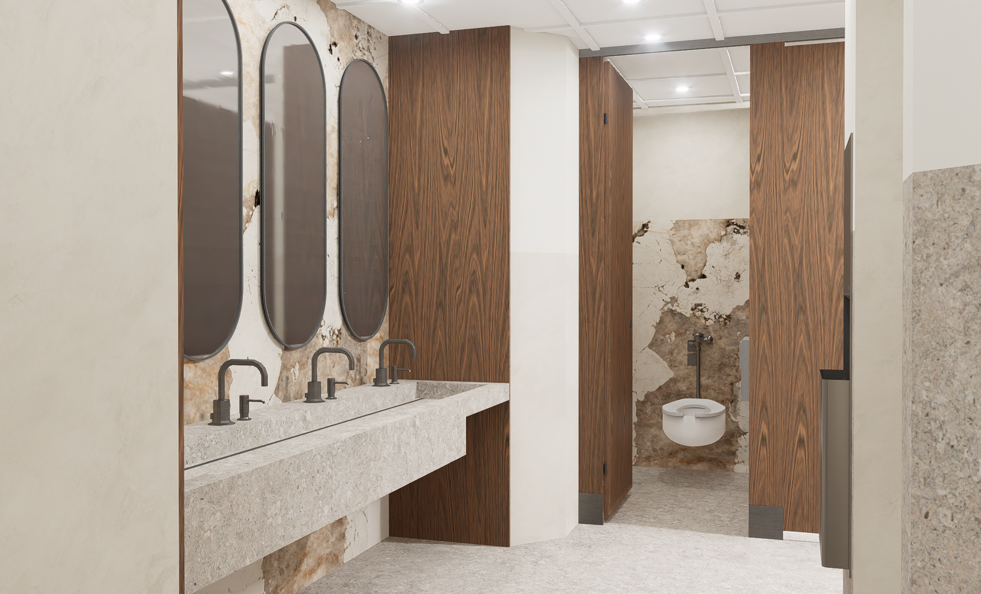 Toilettes publiques avec finitions en pierre et en bois ; lavabos avec miroirs à gauche, cabines à droite.