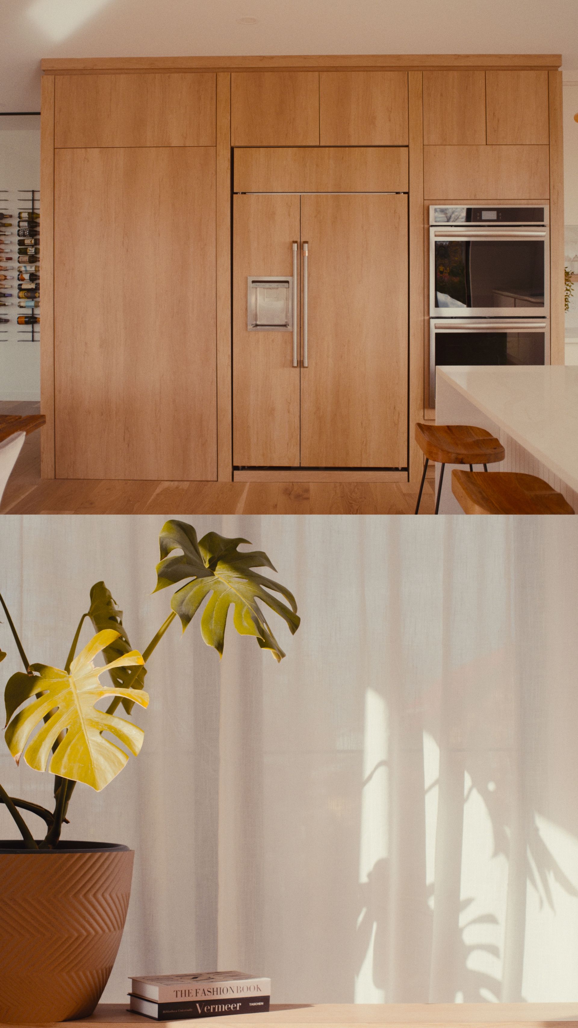 Cuisine avec placards en bois clair, réfrigérateur intégré et plante Monstera en pot.