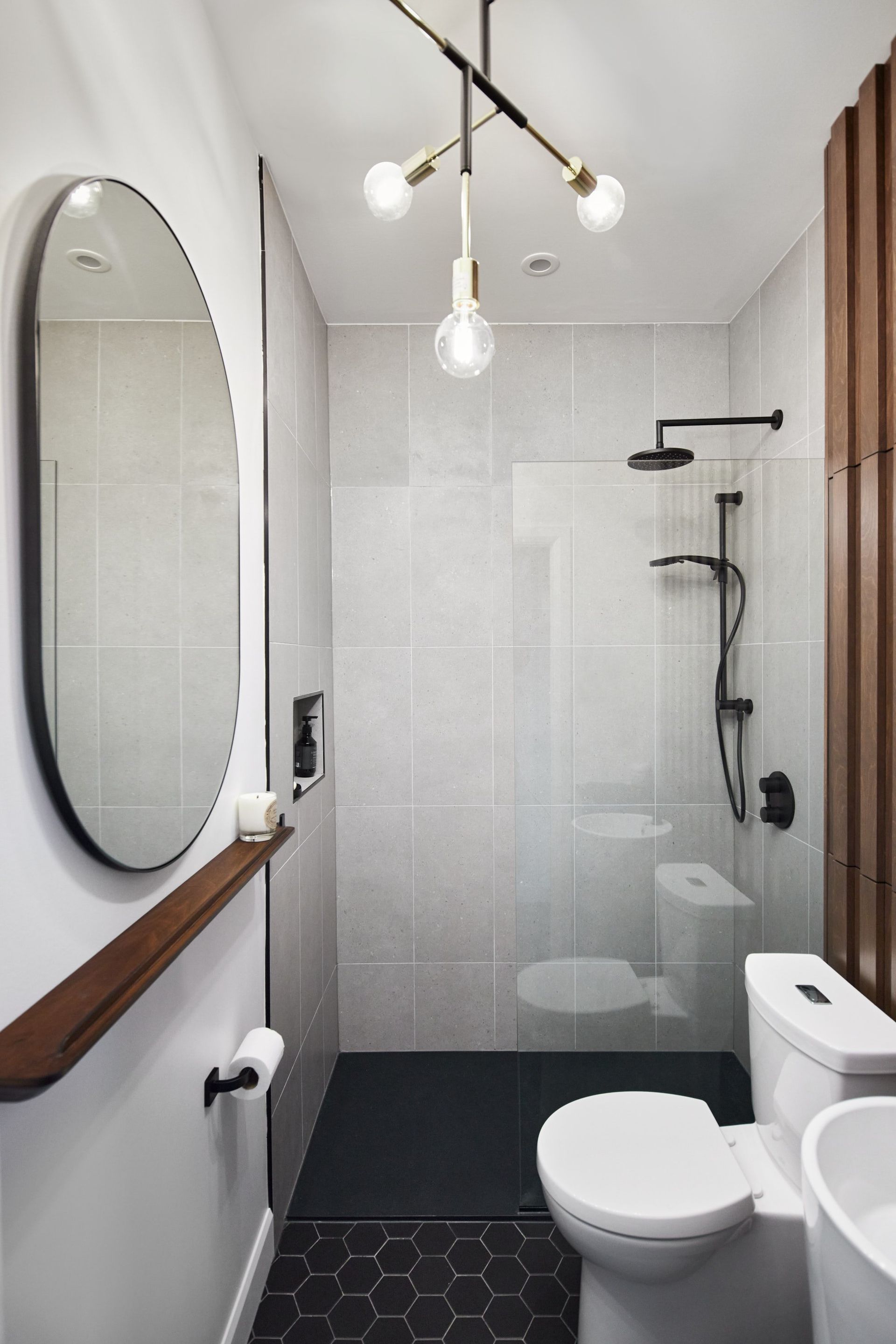 Une salle de bain avec WC , lavabo , miroir et douche.