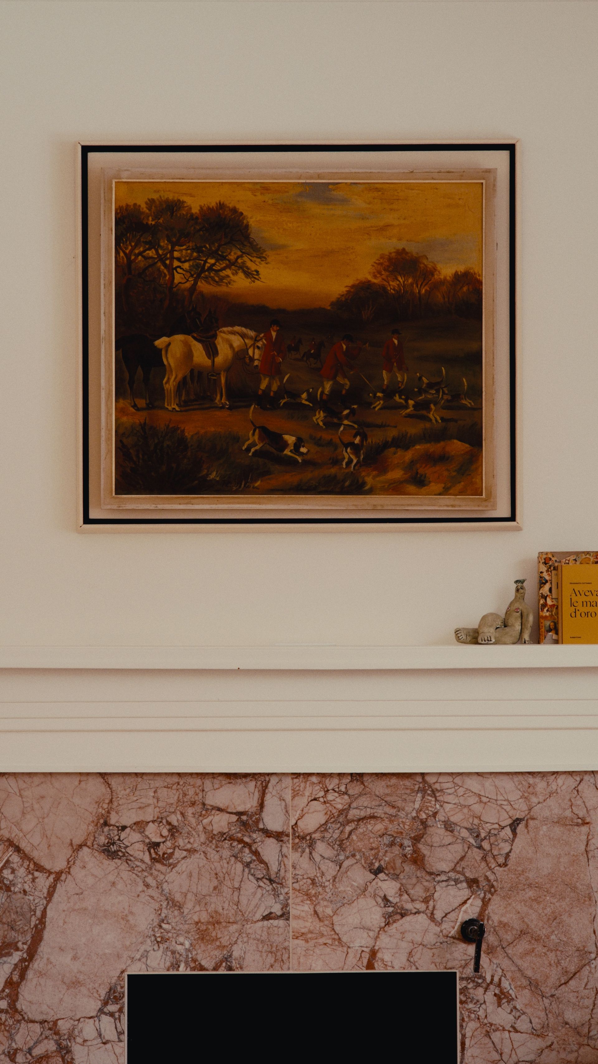 Tableau au-dessus d'une cheminée, représentant un paysage avec des personnages et des animaux, encadré de noir.