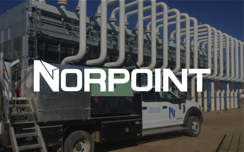 NORPOINT truck in front of industrial equipment with white piping.