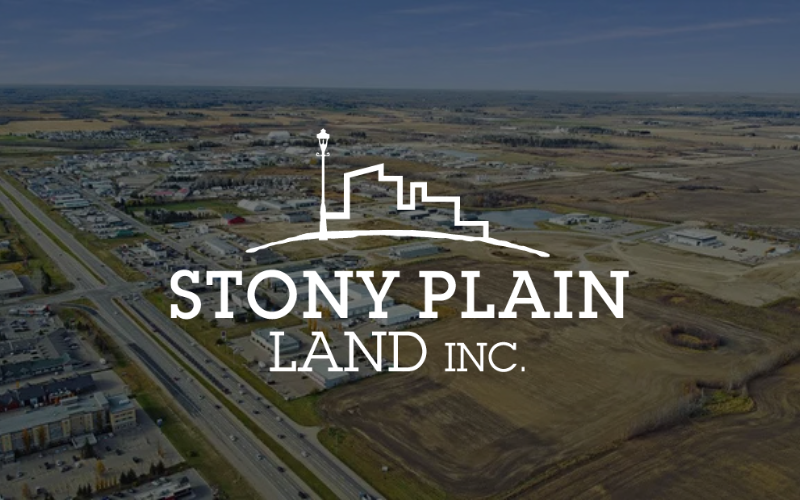 Stony Plain Land Inc. logo over an aerial view of a town and open land.