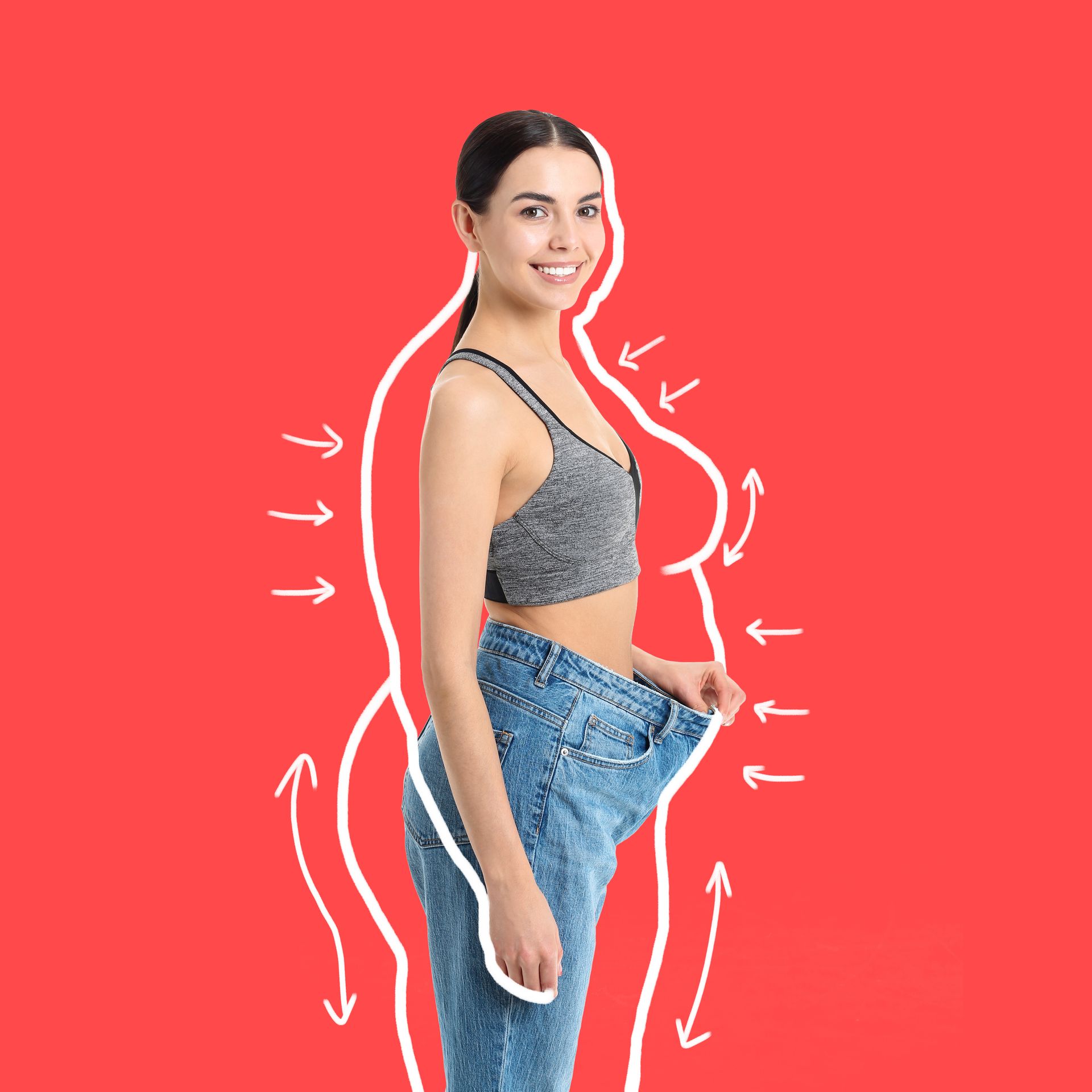 Woman in gray sports bra and jeans showing loose-fitting jeans on a red background with motion arrows