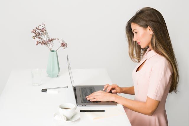 Ung kvinne ved PC – illustrerer nettkurs i sjekking og digital læring hjemmefra.