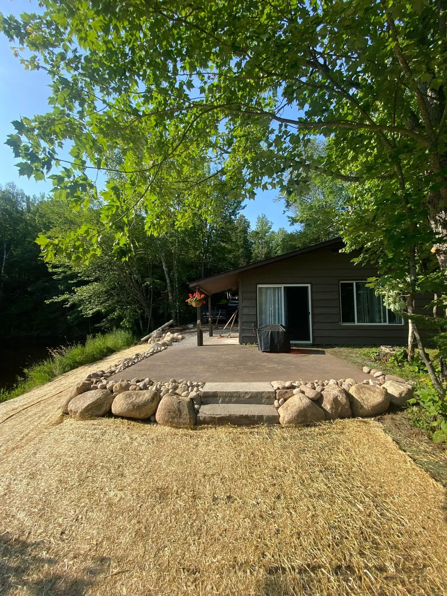 A small house is sitting on top of a hill surrounded by trees.