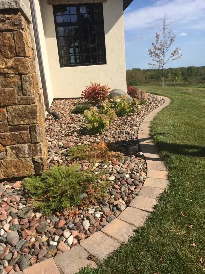 A stone walkway leading up to a house with leaves on the ground.