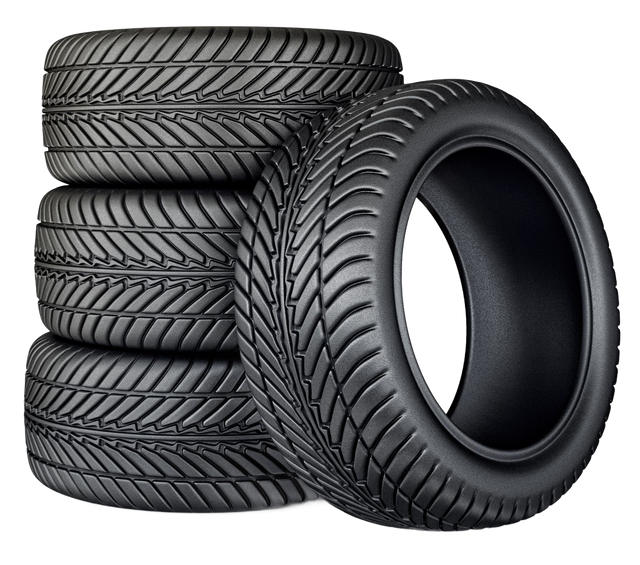 Stack of black car tires with one tire leaning in front