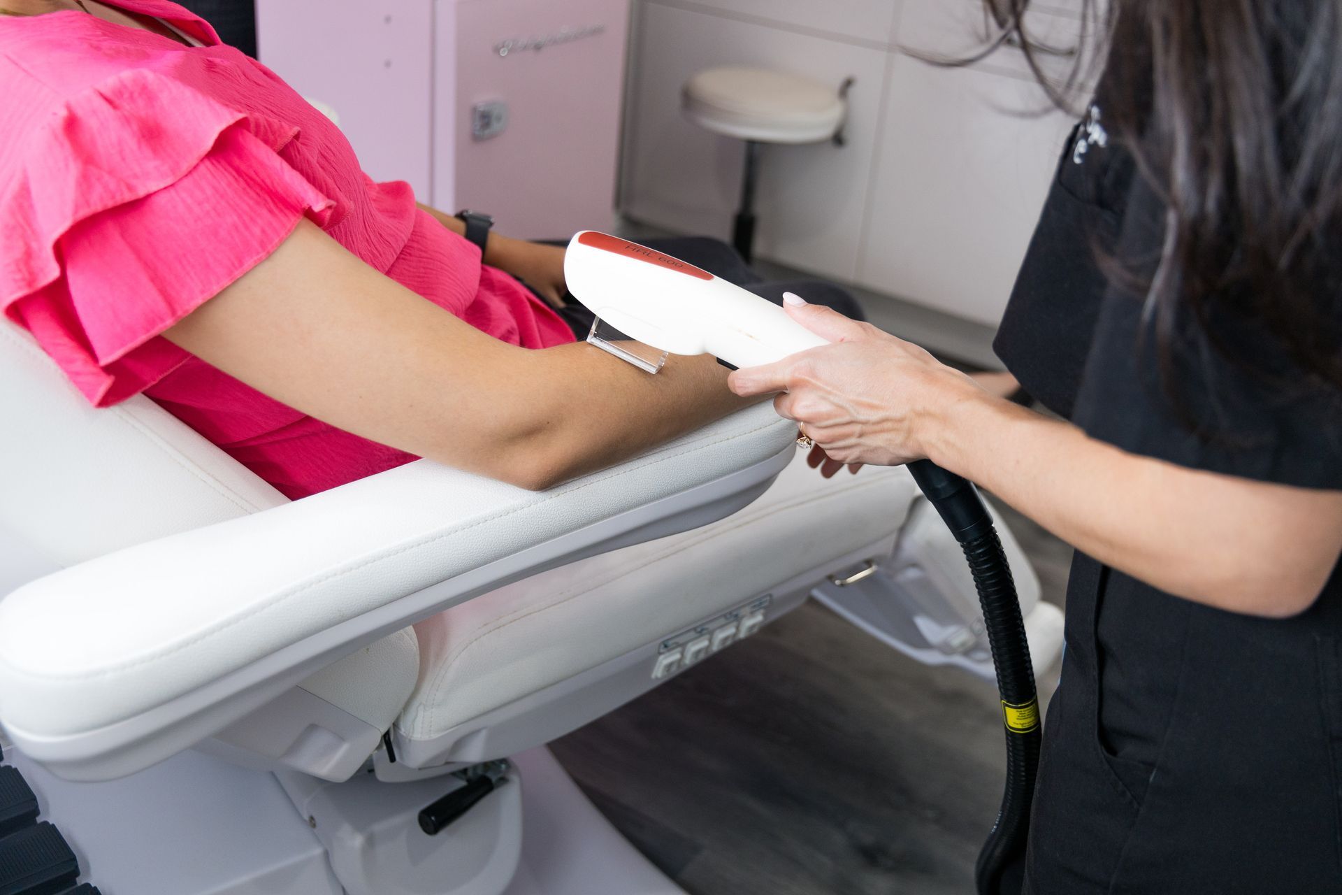 A person is sitting in a chair receiving laser therapy