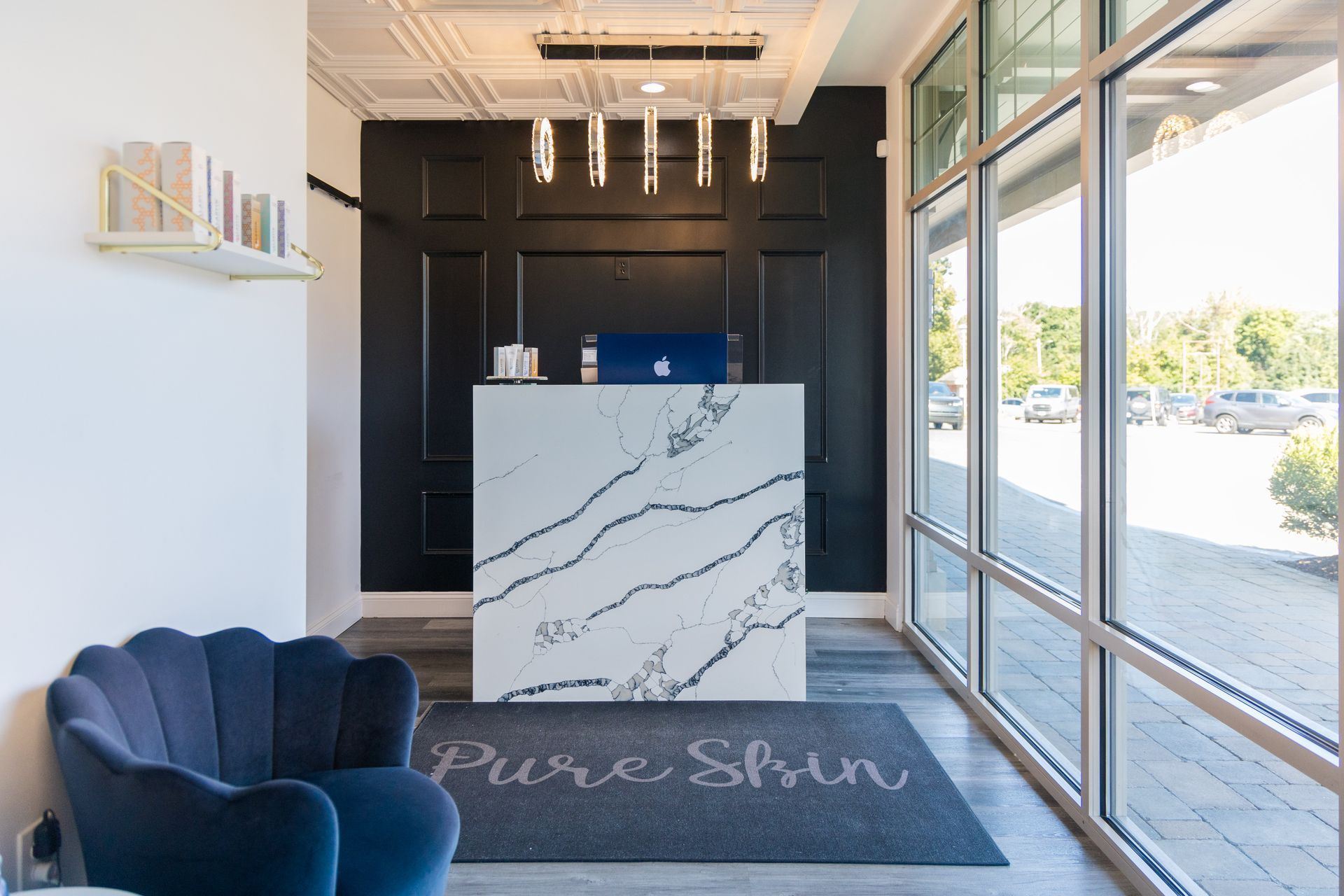 A lobby with a chair and a counter that says pure skin