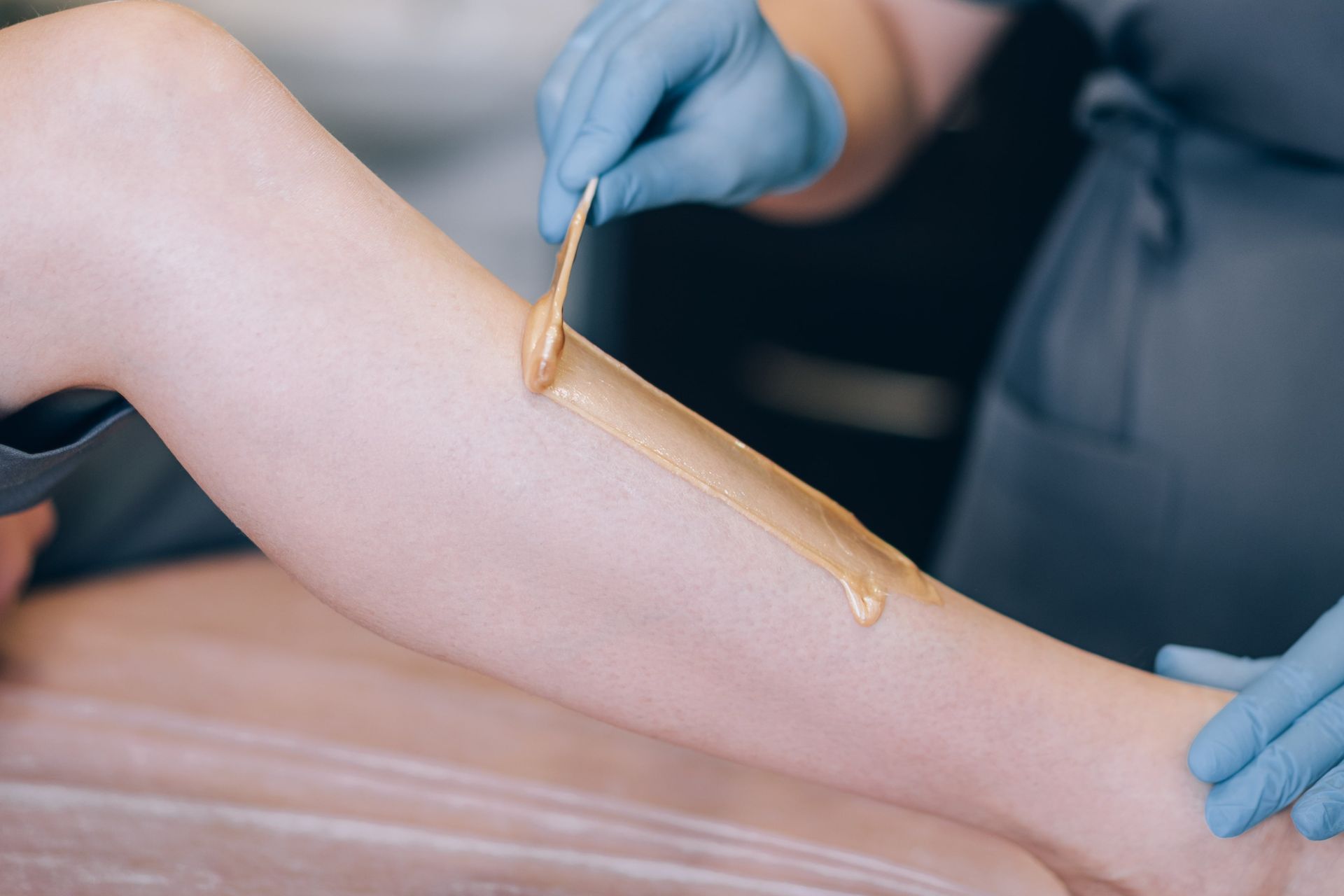 A woman is getting her legs waxed in a beauty salon
