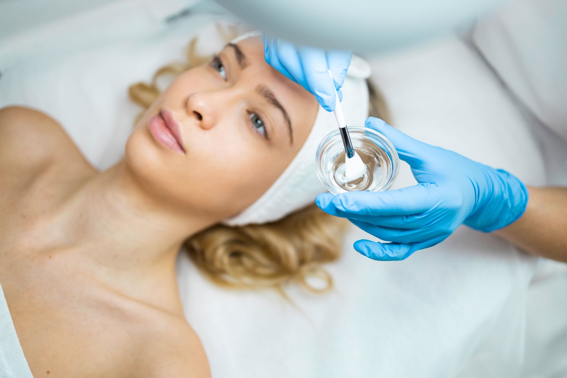 A woman is getting a facial treatment at a beauty salon