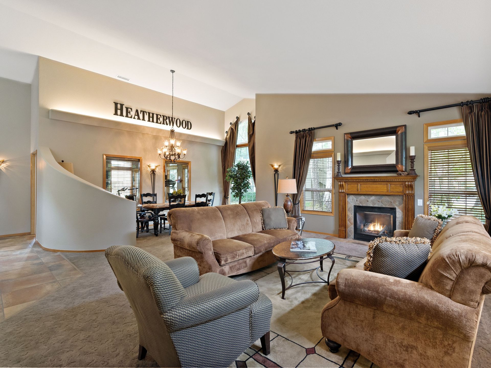Cozy living room with tan sofas, fireplace, and large windows in a home interior