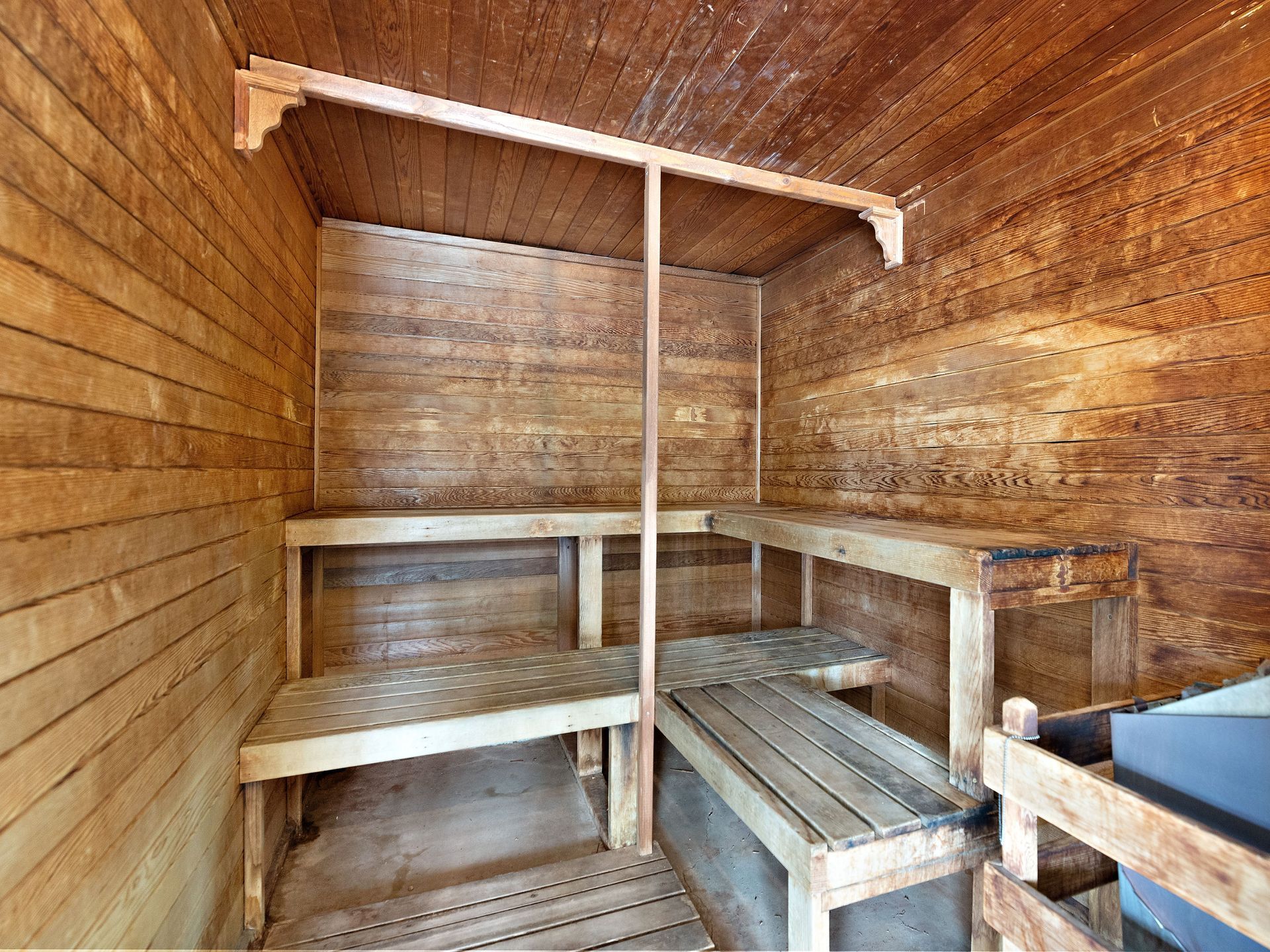 Wood-paneled sauna with wooden benches and shelves inside