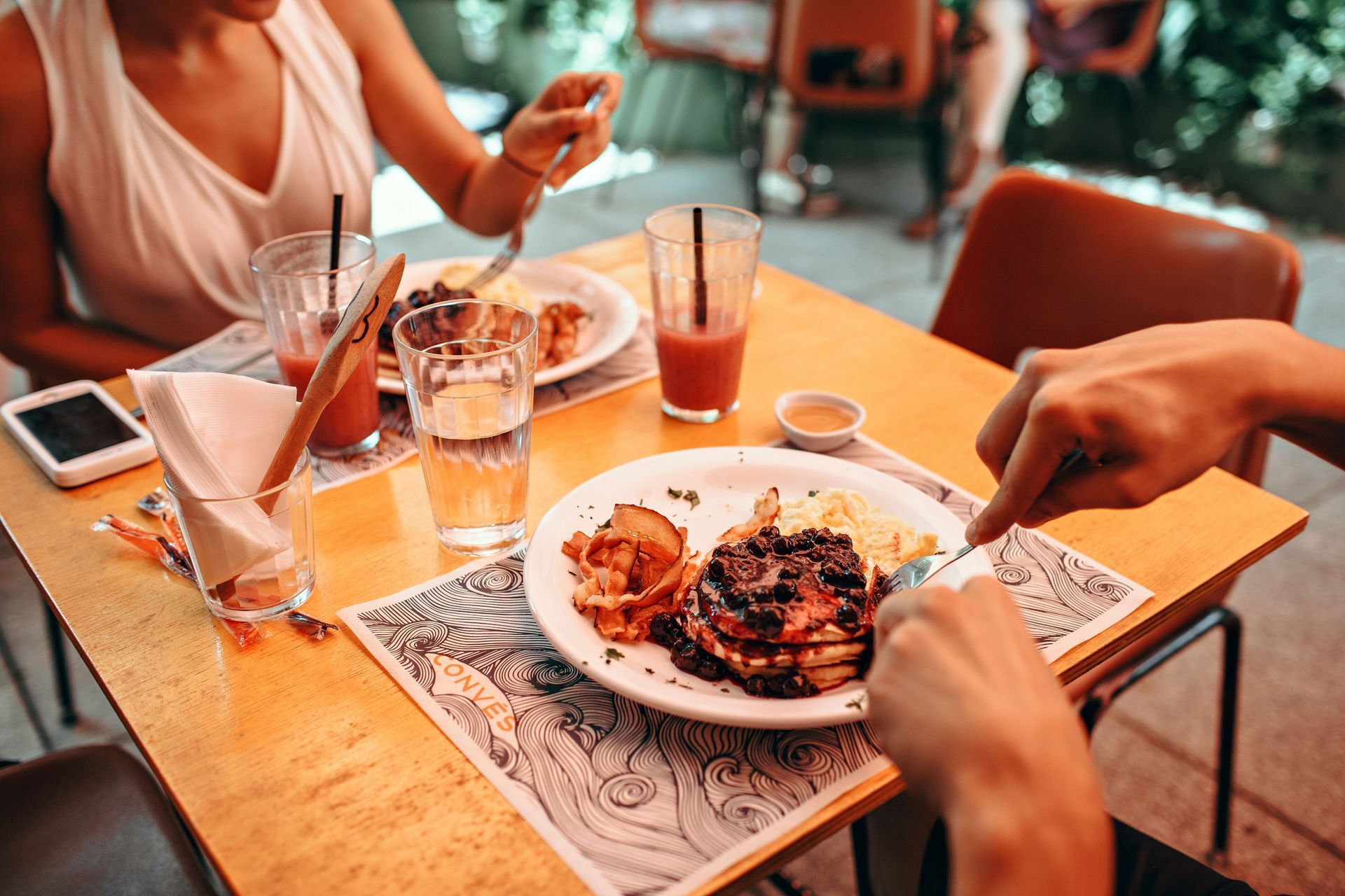 Overhead view of several plated dishes and drinks on a table with a red tablecloth