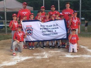 Youth baseball team posing with banner reading “2016 9-4-1 Year Old Pennsylvania District 8 Champions.”