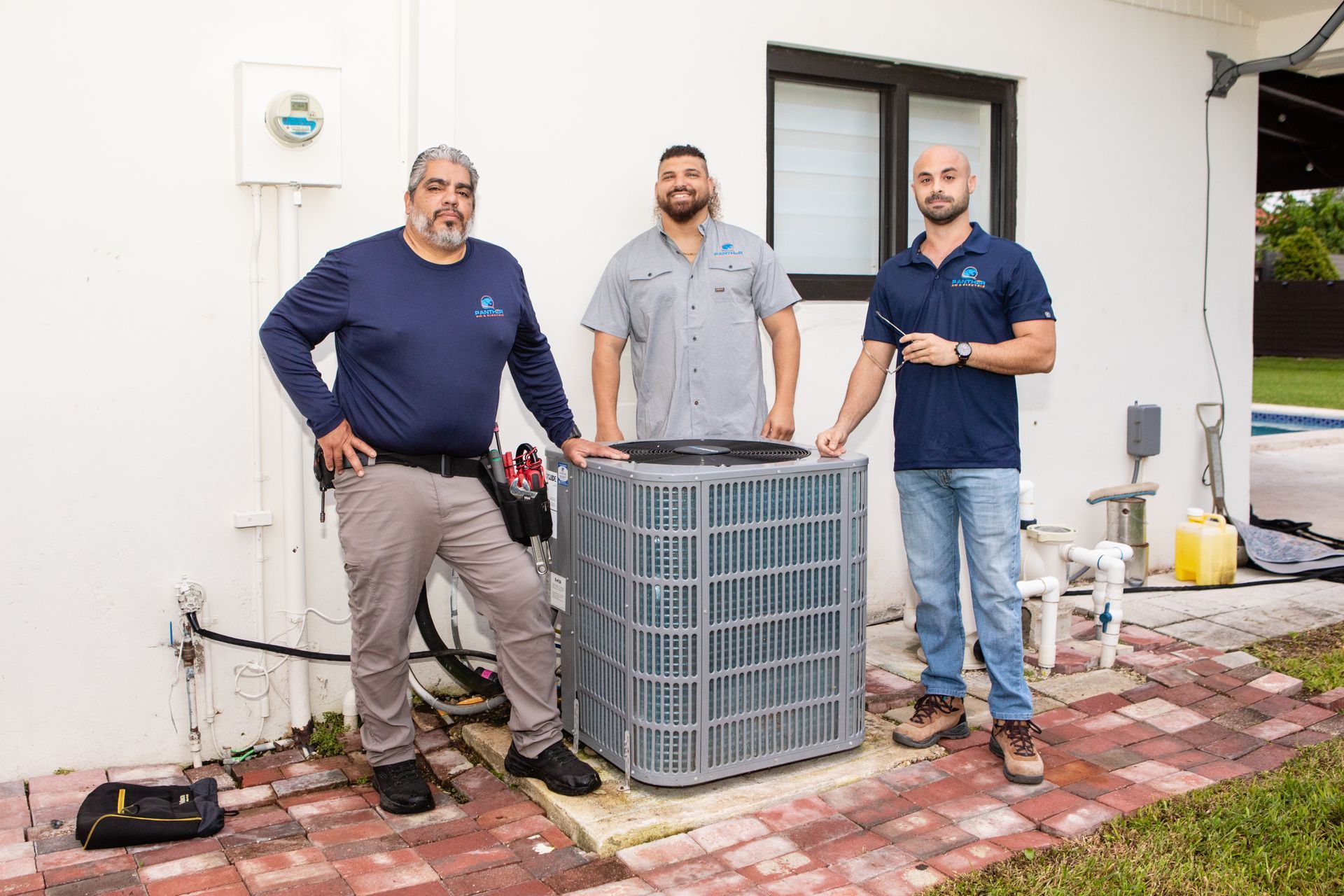 An air conditioner is sitting on the side of a building next to a window.