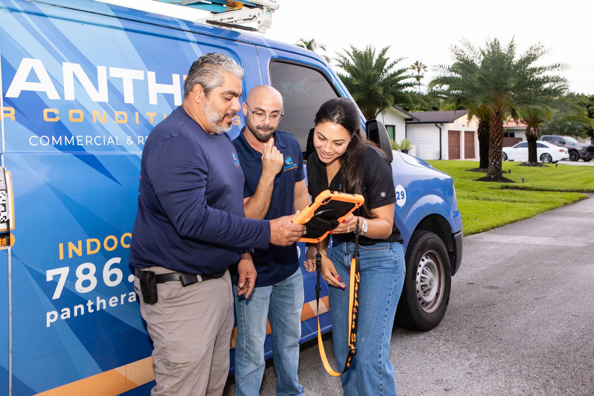 A panther air conditioning van is parked on the side of the road.