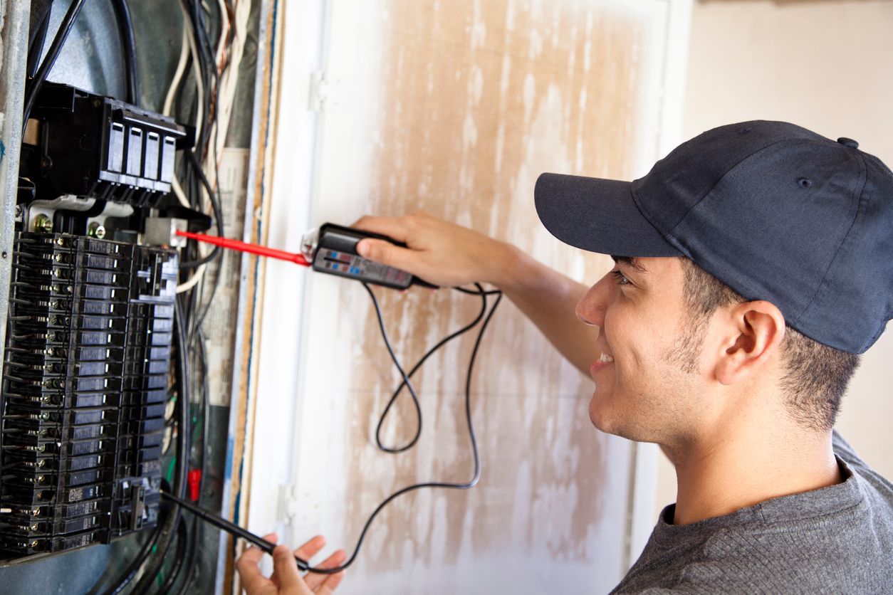 A man is working on an electrical panel with a screwdriver.