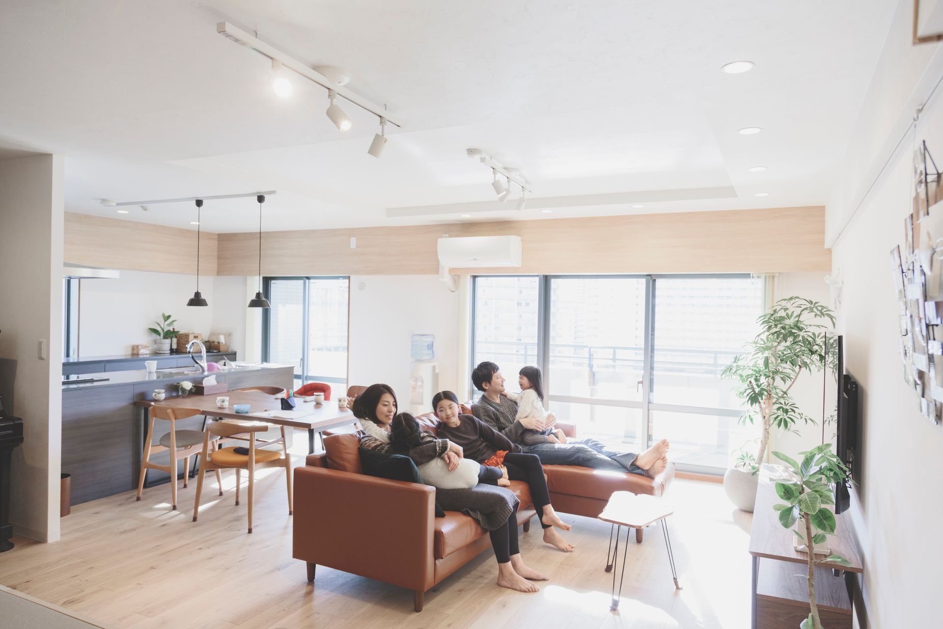 A group of people are sitting on a couch in a living room.