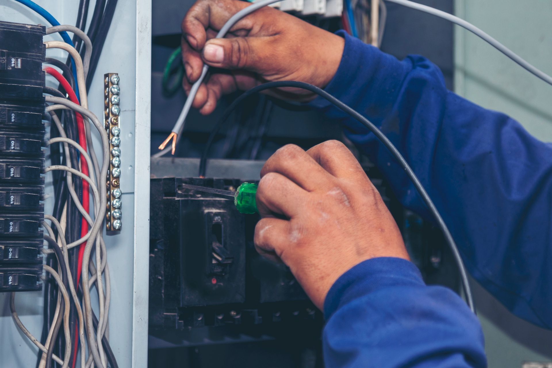 Electrician inspecting a residential electrical panel and surge protection system before hurricane.