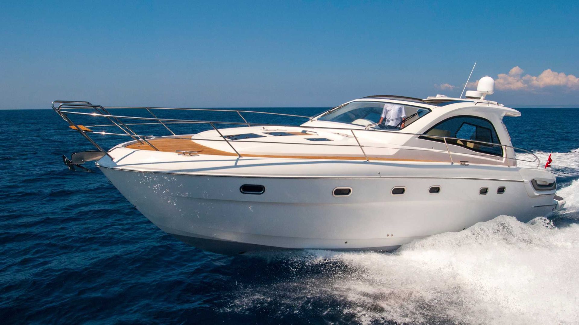A white boat is floating on top of a body of water.