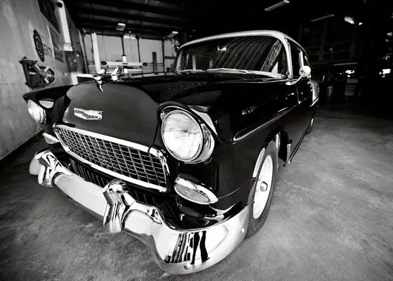Black vintage car in a garage, shown from the front with shiny chrome details. | Sparks Tire & Auto
