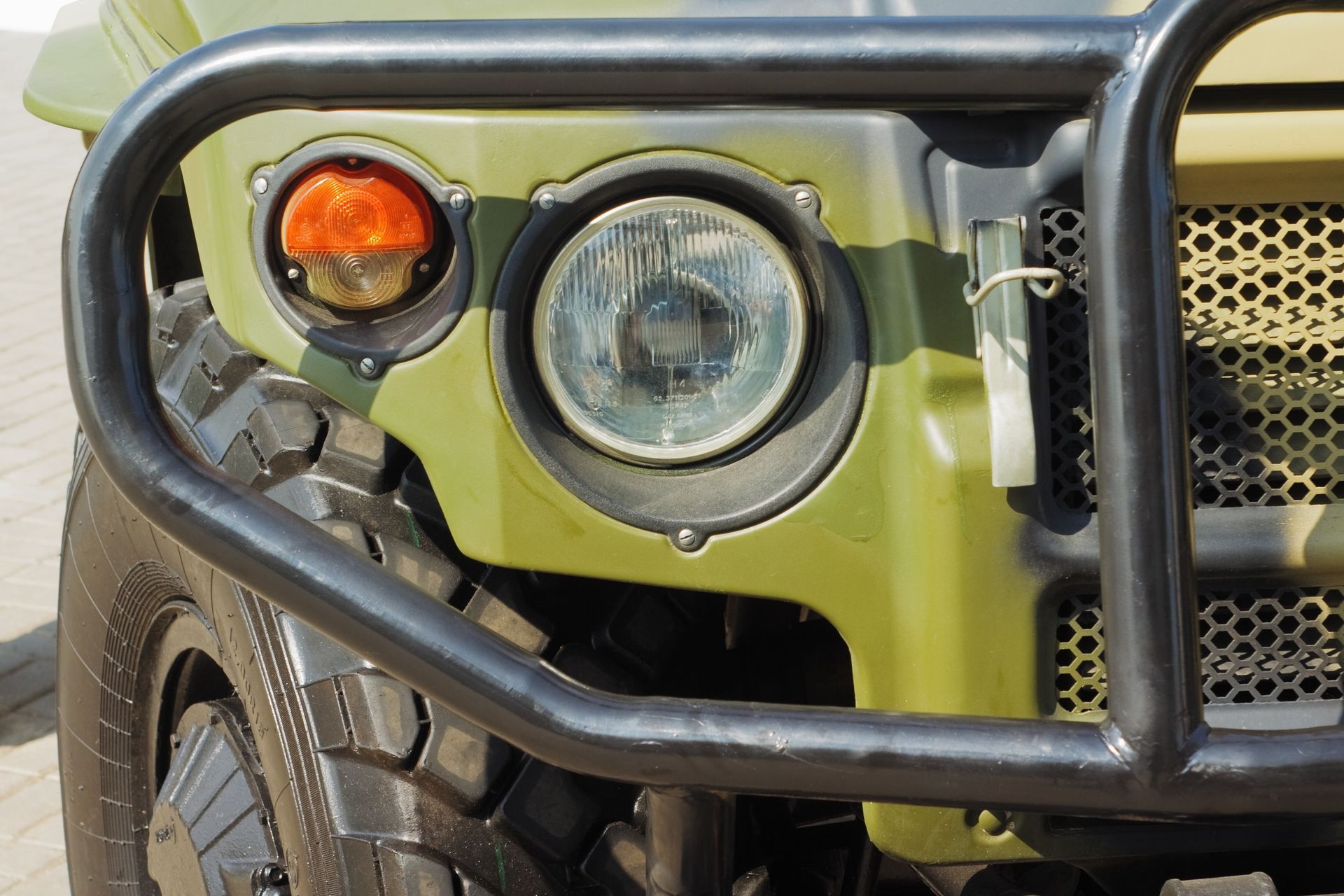 Close-up of a green off-road vehicle’s front headlight | Sparks Tire & Auto