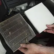 Hands holding a dirty air filter next to a clean white replacement filter | Sparks Tire & Auto