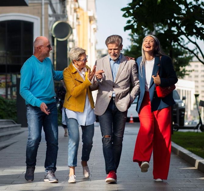 A group of people are walking down a sidewalk.