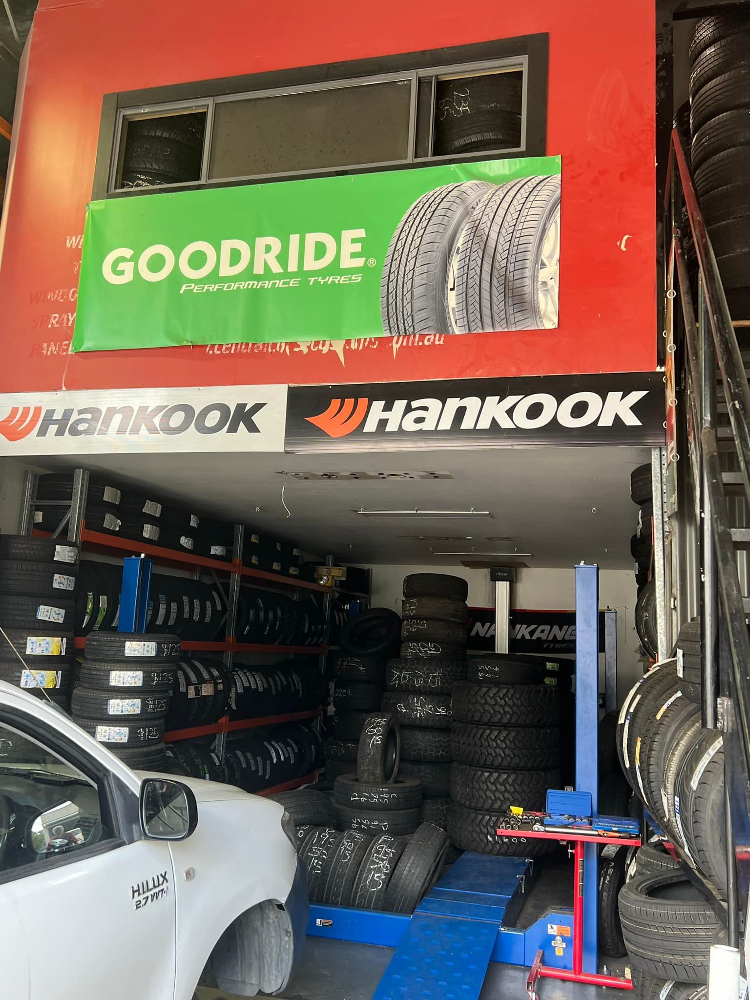 A white truck is parked in front of a tire store. — Budget Tyre Shed In Charmhaven, NSW