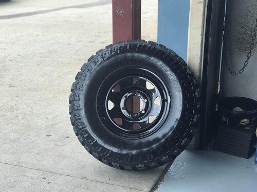A tyre and wheel leaned against the door frame — Budget Tyre Shed In Charmhaven, NSW