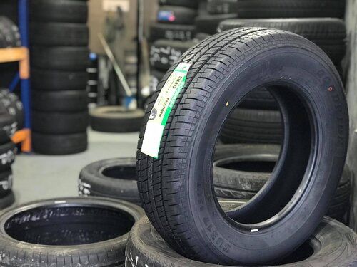 A close up of a tyre stacked on Lots of other Tyres in a warehouse — Budget Tyre Shed In Charmhaven, NSW