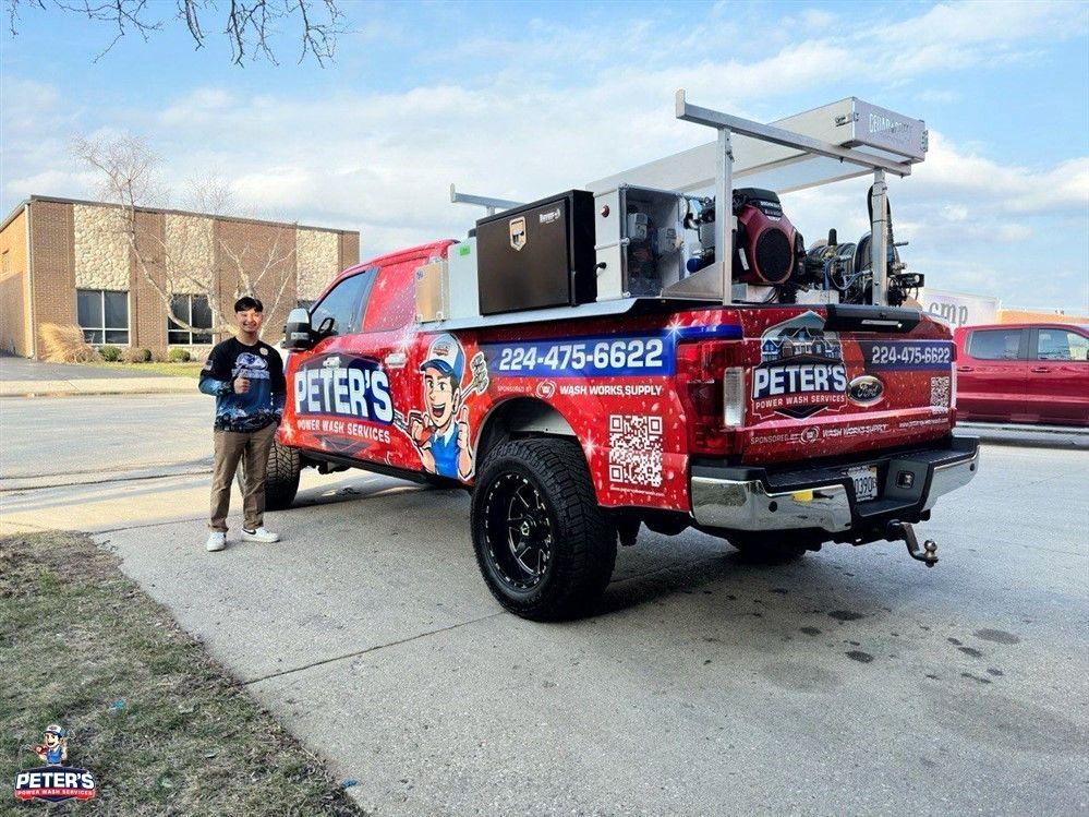 Picture of a Peter Power Washing truck and technician during an HOA Power Washing service, featuring professional cleaning equipment parked outside a residential neighborhood under a clear sky.