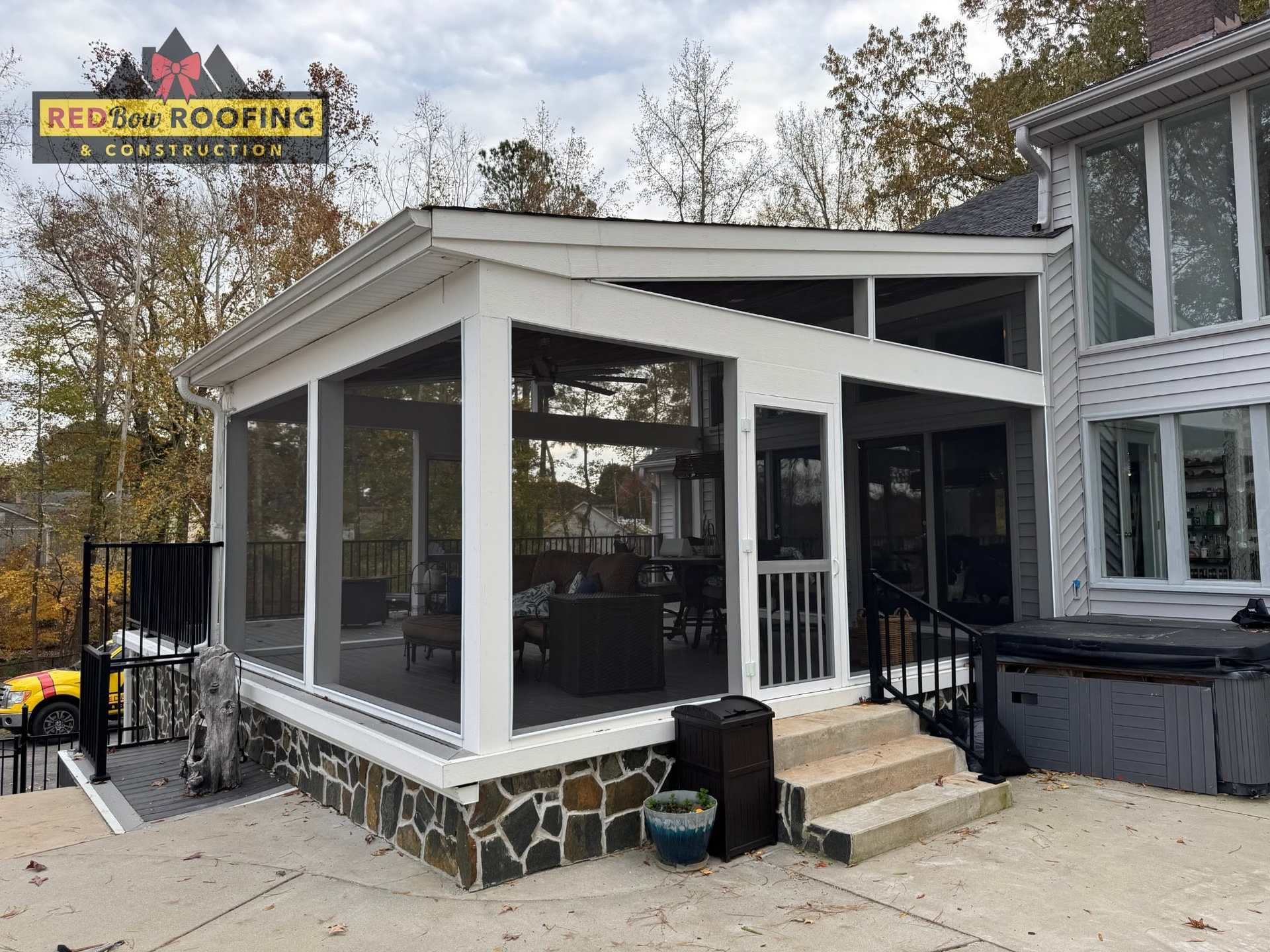 Screened porch addition with white trim and black screens attached to a house
